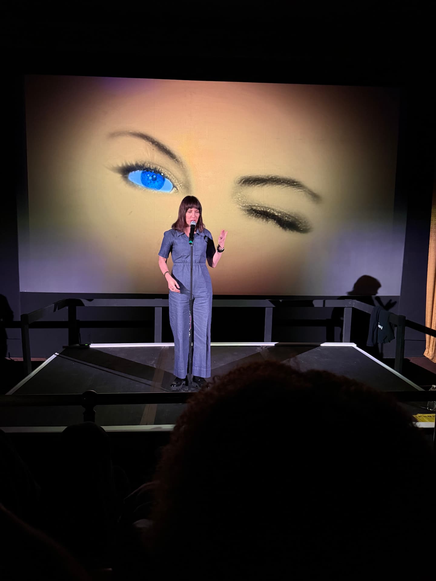 A comedian performing in front of a giant projected image